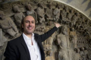 Carlos Nunez in front of instruments of medieval portico Santiago HI-RES